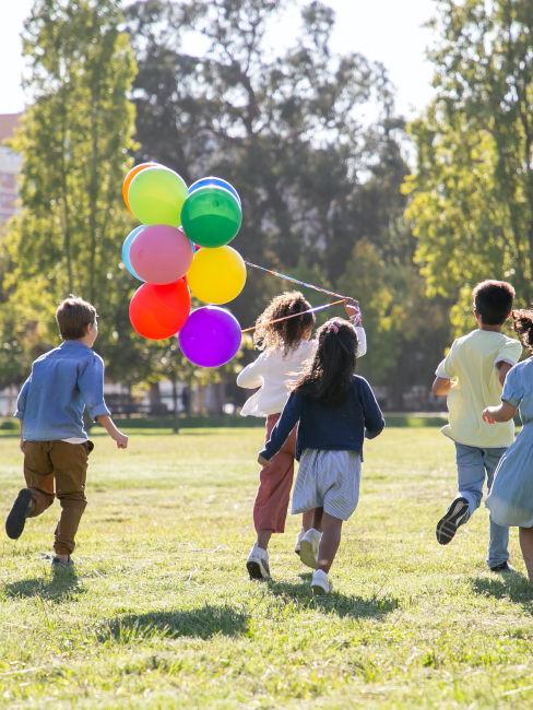 bambini che giocano all'aperto con palloncini