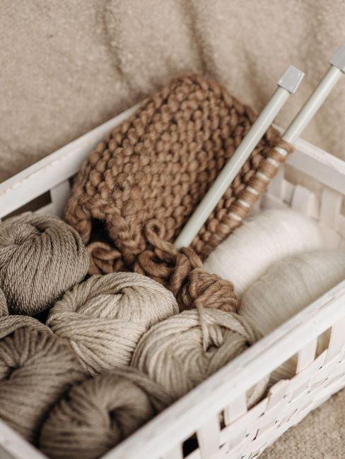 cassetta di legno con gomitoli di lana e ferri