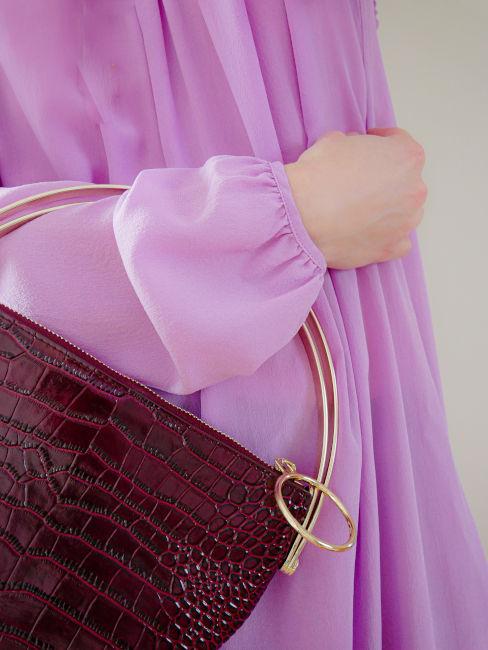 dettaglio vestito viola con borsa