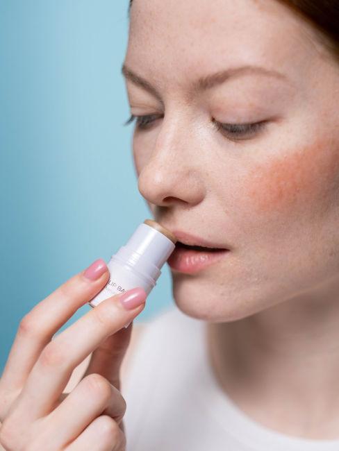 ragazza che applica burrocacao sulle labbra
