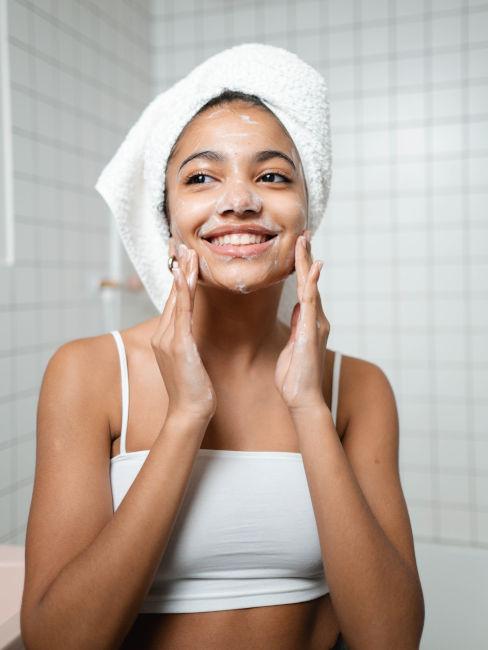 ragazza che applica crema sul viso