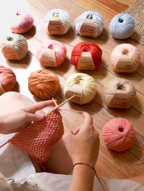 ragazza che lavora a maglia e gomitoli di cotone