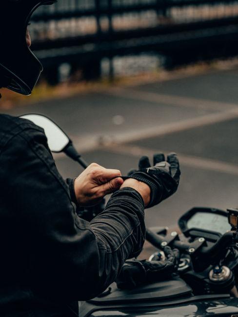 ragazzo che si infila i guanti da moto
