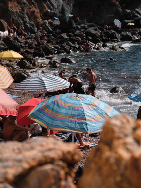 ombrelloni in spiaggia rocciosa
