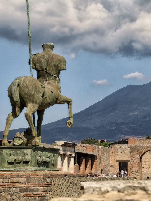 Statua pompei con vesuvio sullo sfondo