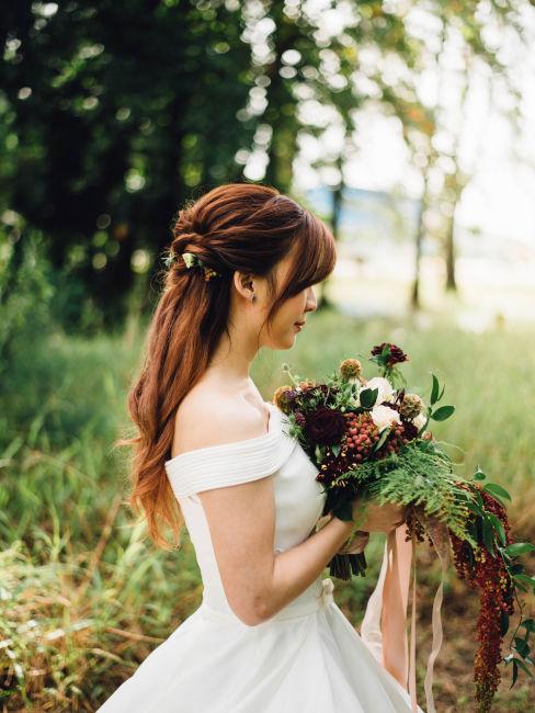 sposa che tiene in mano bouquet fiori autunnali