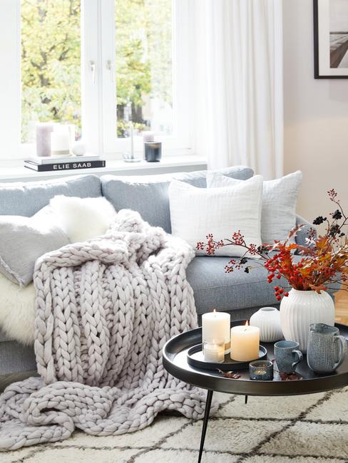 divano azzurro con tessili panna e grigi