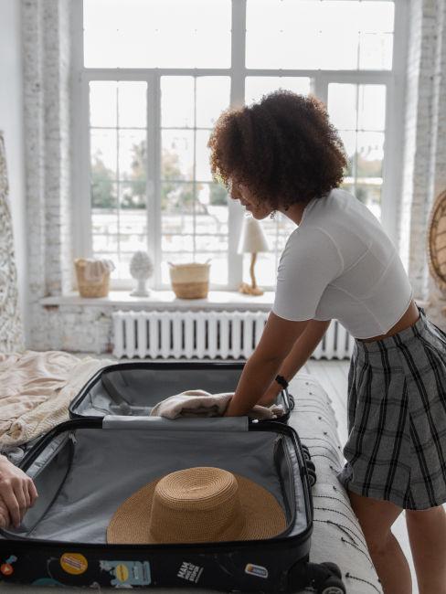 Ragazza che fa la valigia per viaggio