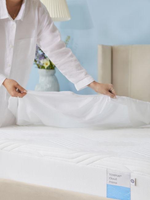 ragazza che mette il coprimaterasso