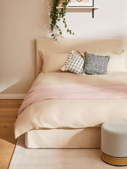 Letto beige con coperta rosa cipria