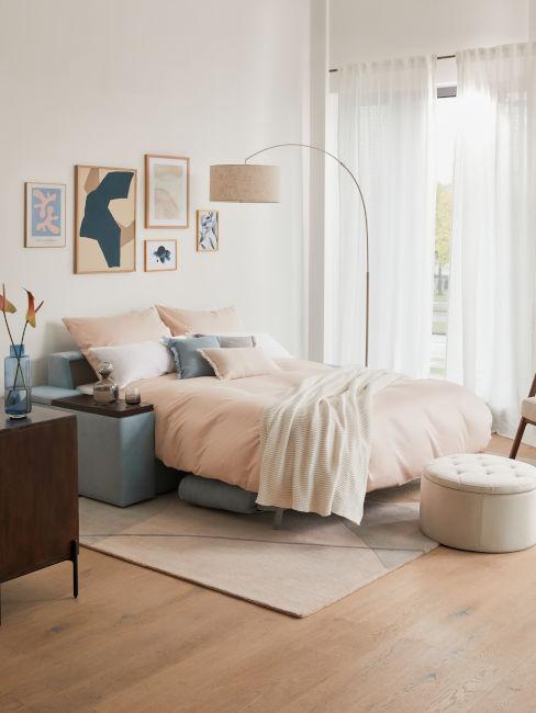 divano letto azzurro con federe rosa
