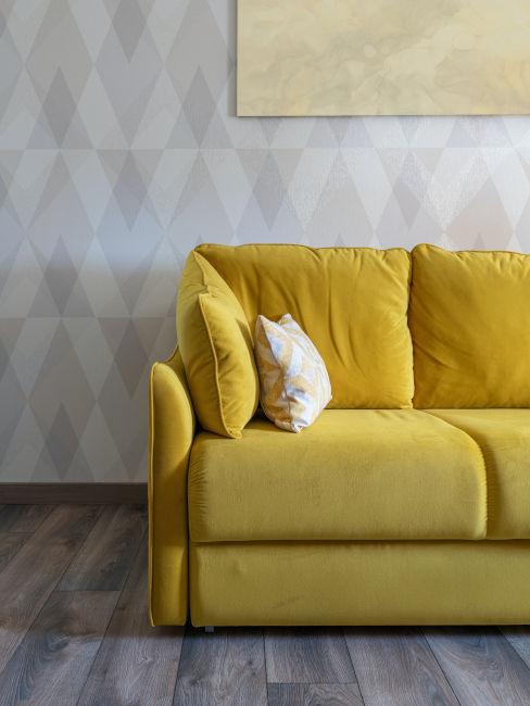 Divano giallo con parete con carta parati geometrica