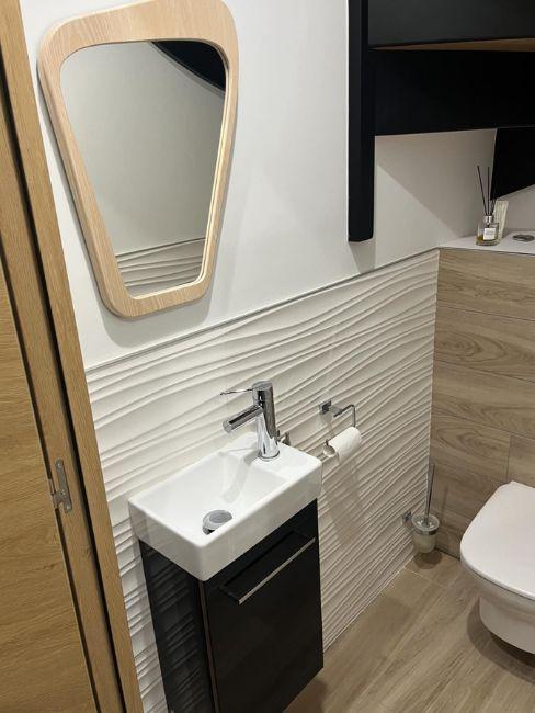 bagno piccolissimo con parete decorata