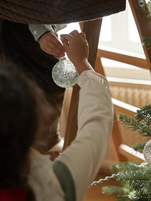 Bimbo che appende decorazione di Natale