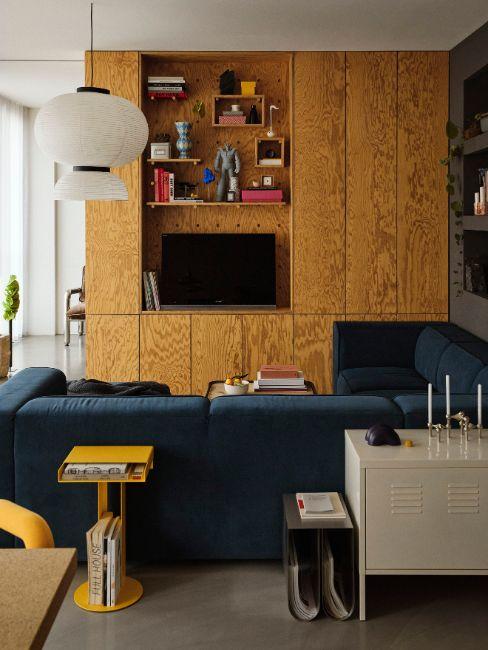 soggiorno con divano blu e libreria in legno