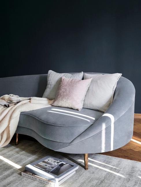 Grijze zitbank met sierkussens en zachte beige plaid