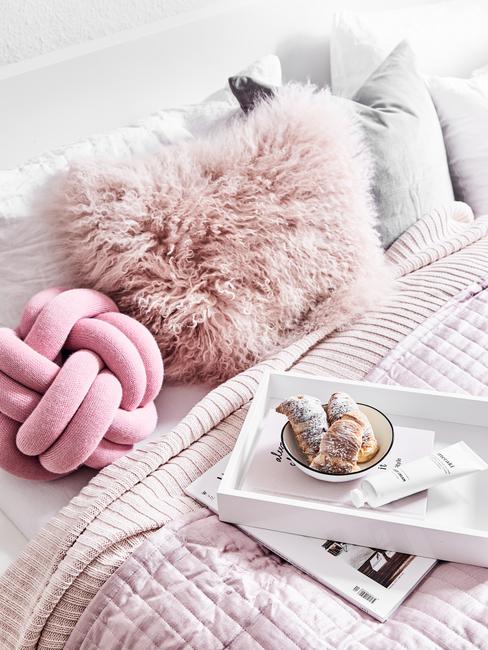 Zachte kussens in roze op het bed