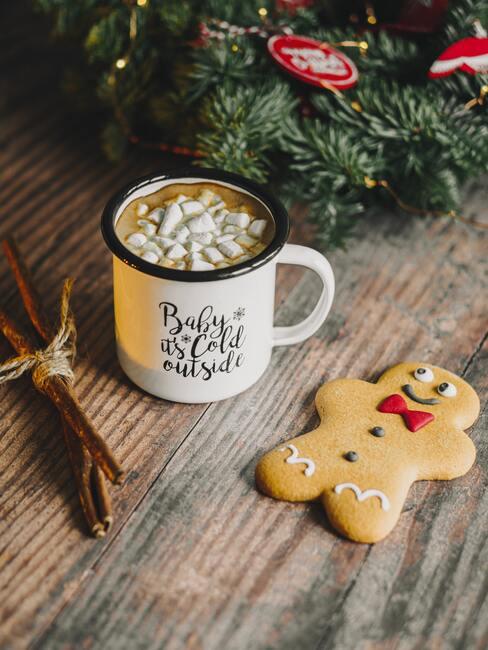 Kerstkoekjes met kop melk naast een kerstkrans
