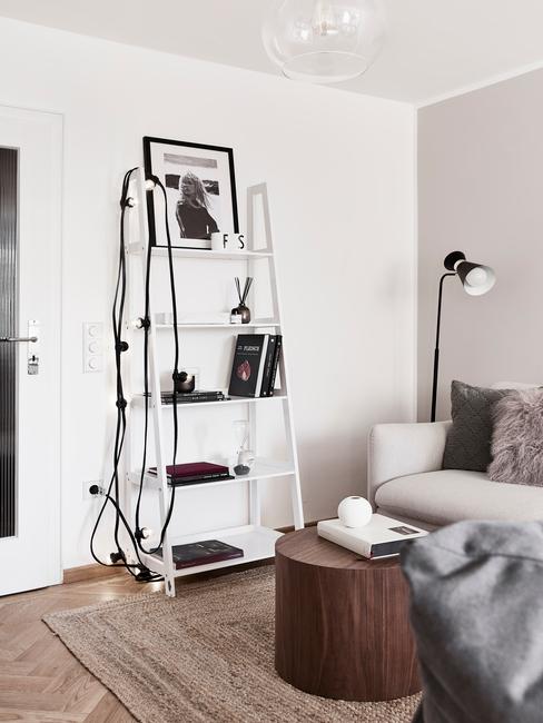 Decoratieve ladder in wit naast een zitbank in beige