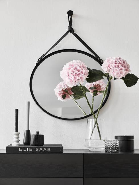 Zwart dressoir met ronde wandspiegel en elie saab boek