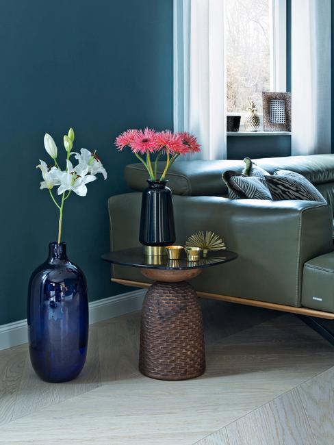 moderne woonkamer met donkerblauwe muur en groene leren bank