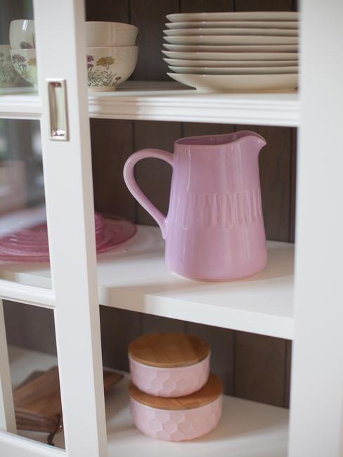 binnenkant vitrinekast met roze waterkan