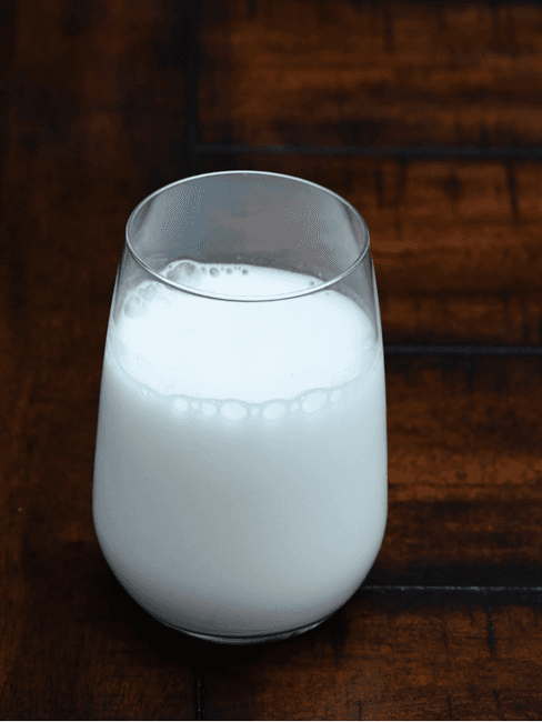 Glas melk op donker hout