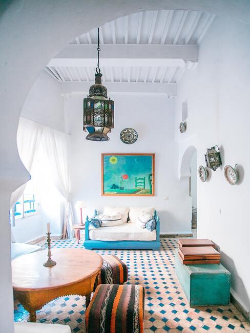 Lichte kamer met patchwork-tegels en een blauwe bank met witte kussens