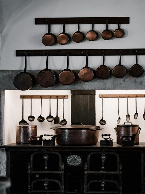 Frituurpan-schoonmaken-2 Frituurpan schoonmaken: diverse pannen hingen aan haken in de keuken