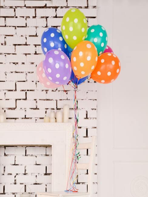 Kleurrijke ballonnen naast een wit dressoir