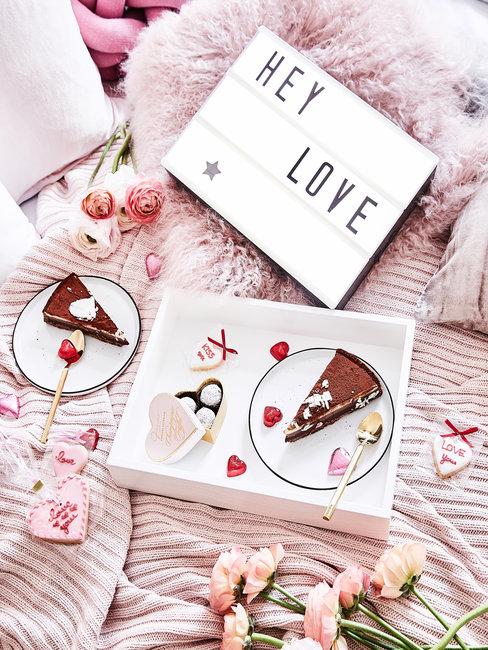 Roze deken met chocoladetaart, hartjes en lichtbox