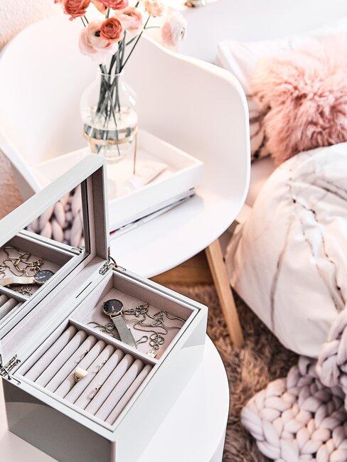 witte stoel met roze bloemen en grijze sieradendoos