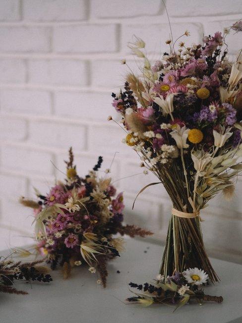 Boeket met droogbloemen voor witte tegels en op een witte tafel in boho-stijl