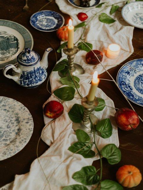 Houten tafel met witte tafellooper, kaarsen en delfts blauw servies