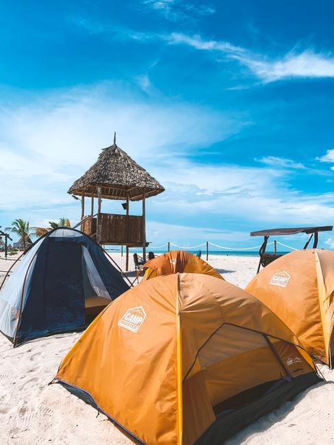 Goedkoop op vakantie Camperen op het strand in gele tenten met een blauwe lucht