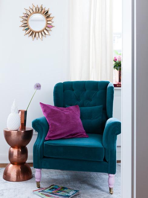 petrol kleur stoel met paarse kussen en metalen bijzettafel