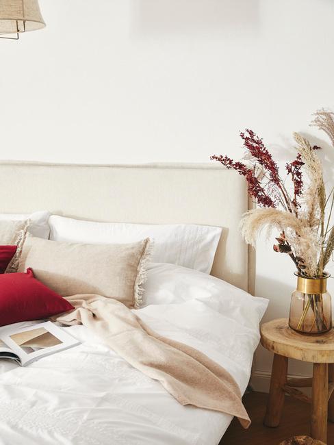 beige boxspring met beige en rode kussens