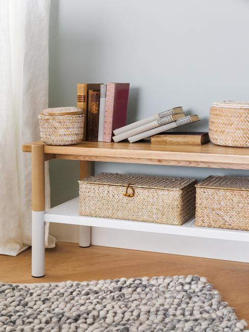 Taup kleurige muur met bankje en rotan opbergbakjes