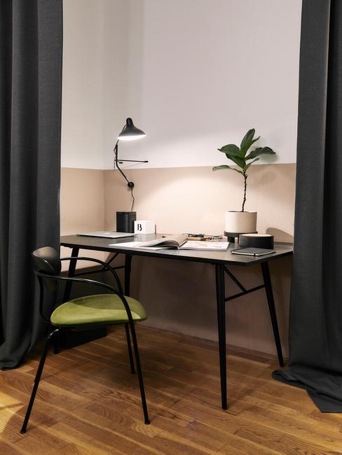 zwart bureau met een zwarte stoel met groen kussen