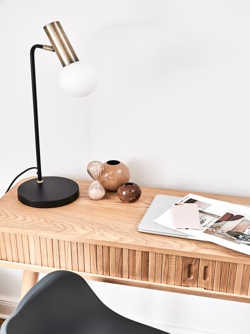 houten bureau met een zwart gouden lamp