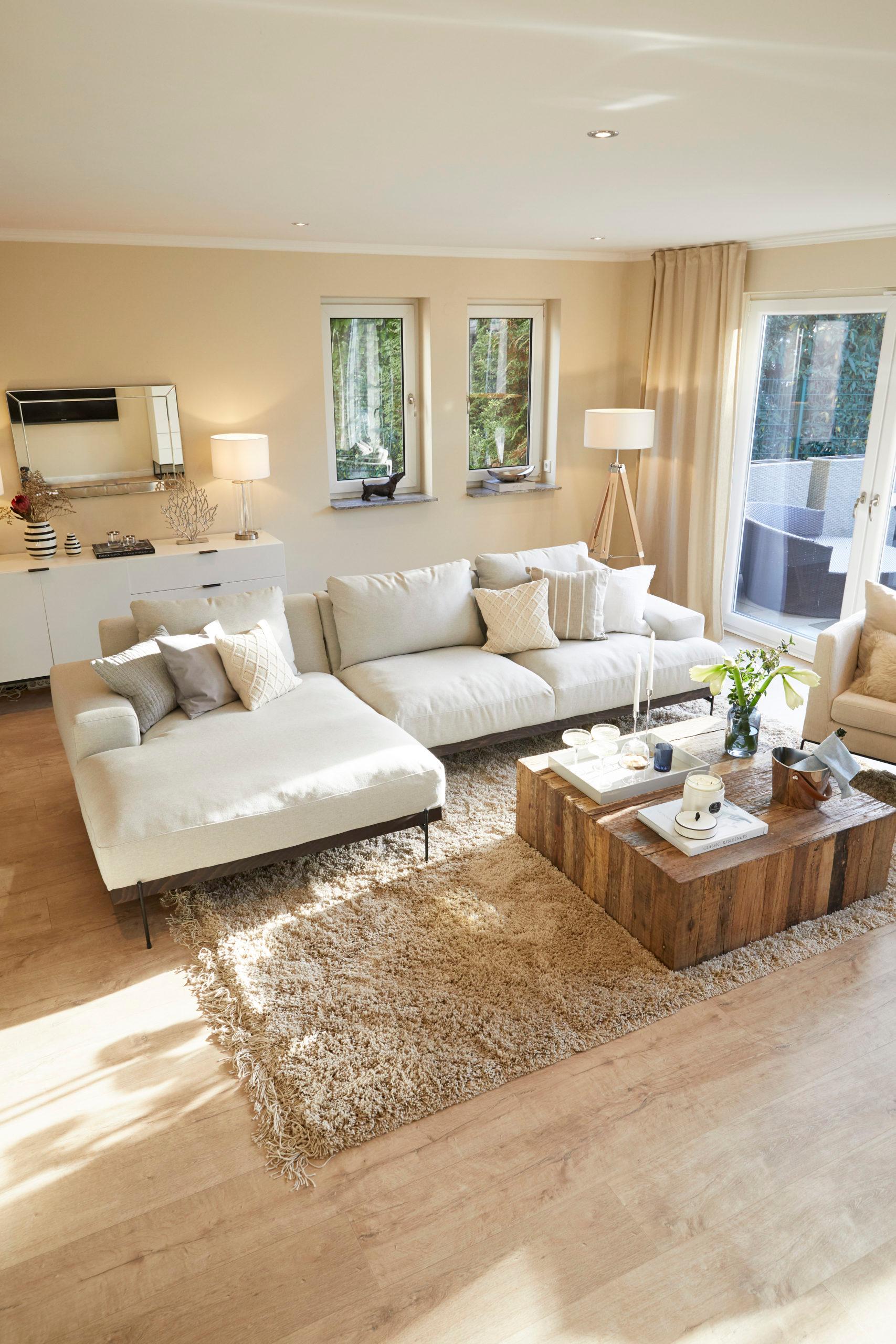 Kleurenkaart beige muur met zandkleurige hoekbank met houten salontafel