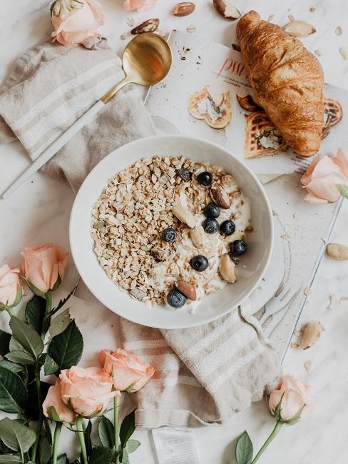 Moederdagontbijt Heading Gedekte tafel met aotmeal croissant en roze