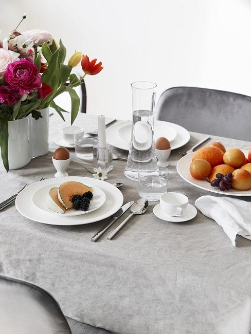 Moederdagontbijt op wit servies op grijze tafel met stoel