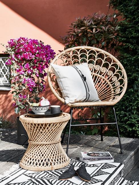 Rotan meubels voor oud roze huis met bloemen