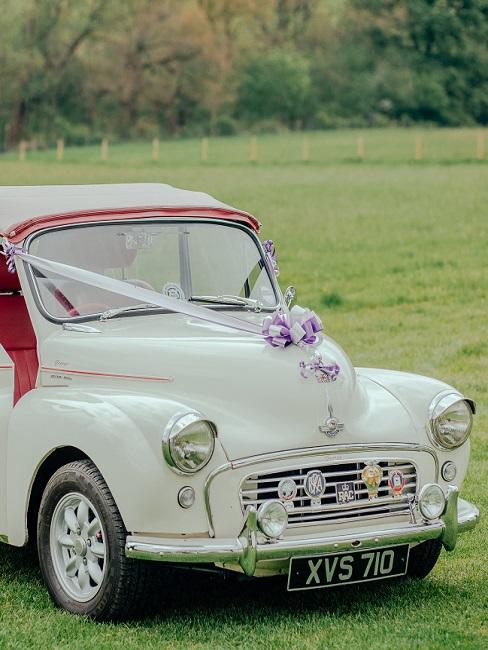 Huwelijksdecoratie met bloemen op een witte auto