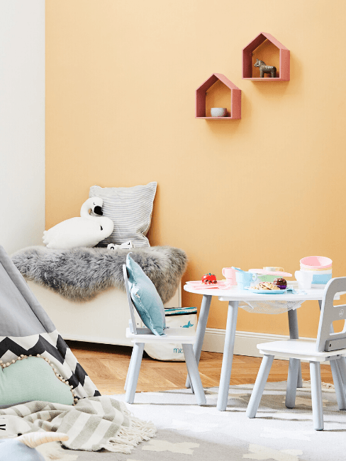 Kinderkamer met kindertafel en kinderstoelen, tipi en zitbank