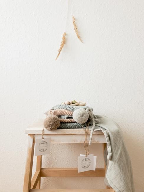 babykleding op houten krukje