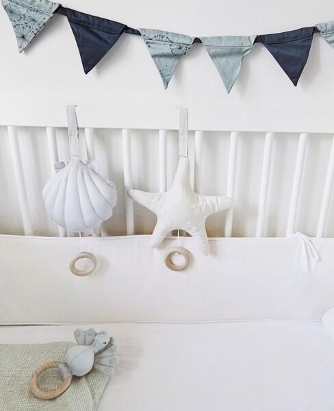 blauw en grijze slinger boven een eit baby bed