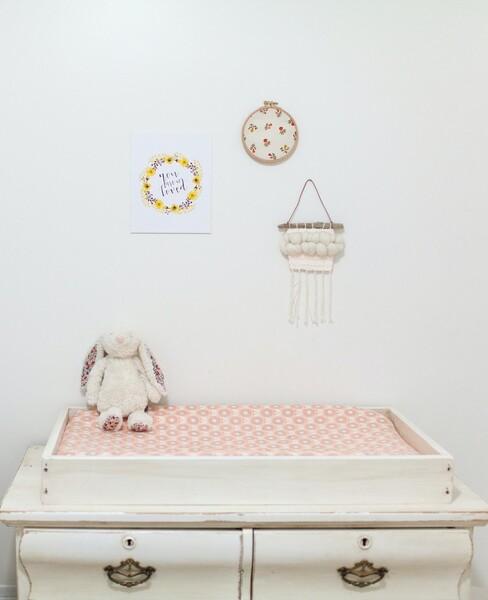 een witte commode met roze aankleedmat en konijn