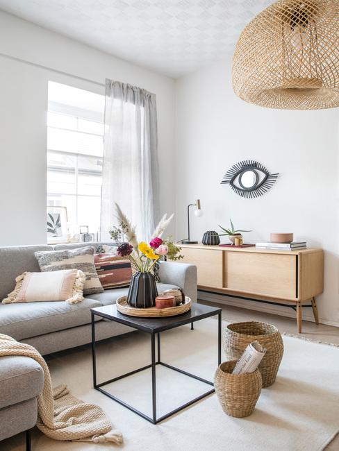 Moderne woonkamer met grijze zitbank en houten dressoir en zwarte salontafel